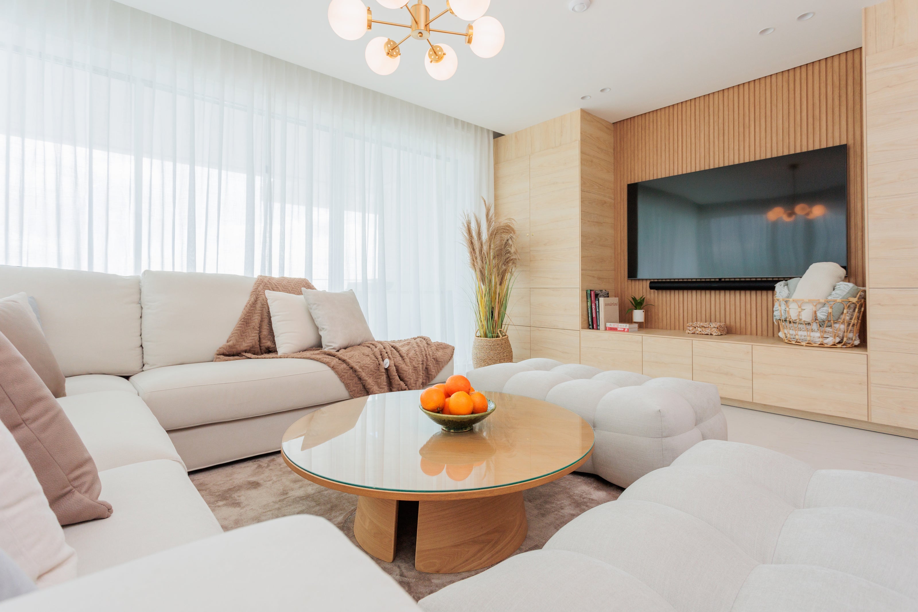 elegant luxury living room interior design with wooden coffee table, cream sofa, soft ottomans, and beige rug available in benalmadena, marbella, bel air, malaga, costa del sol.