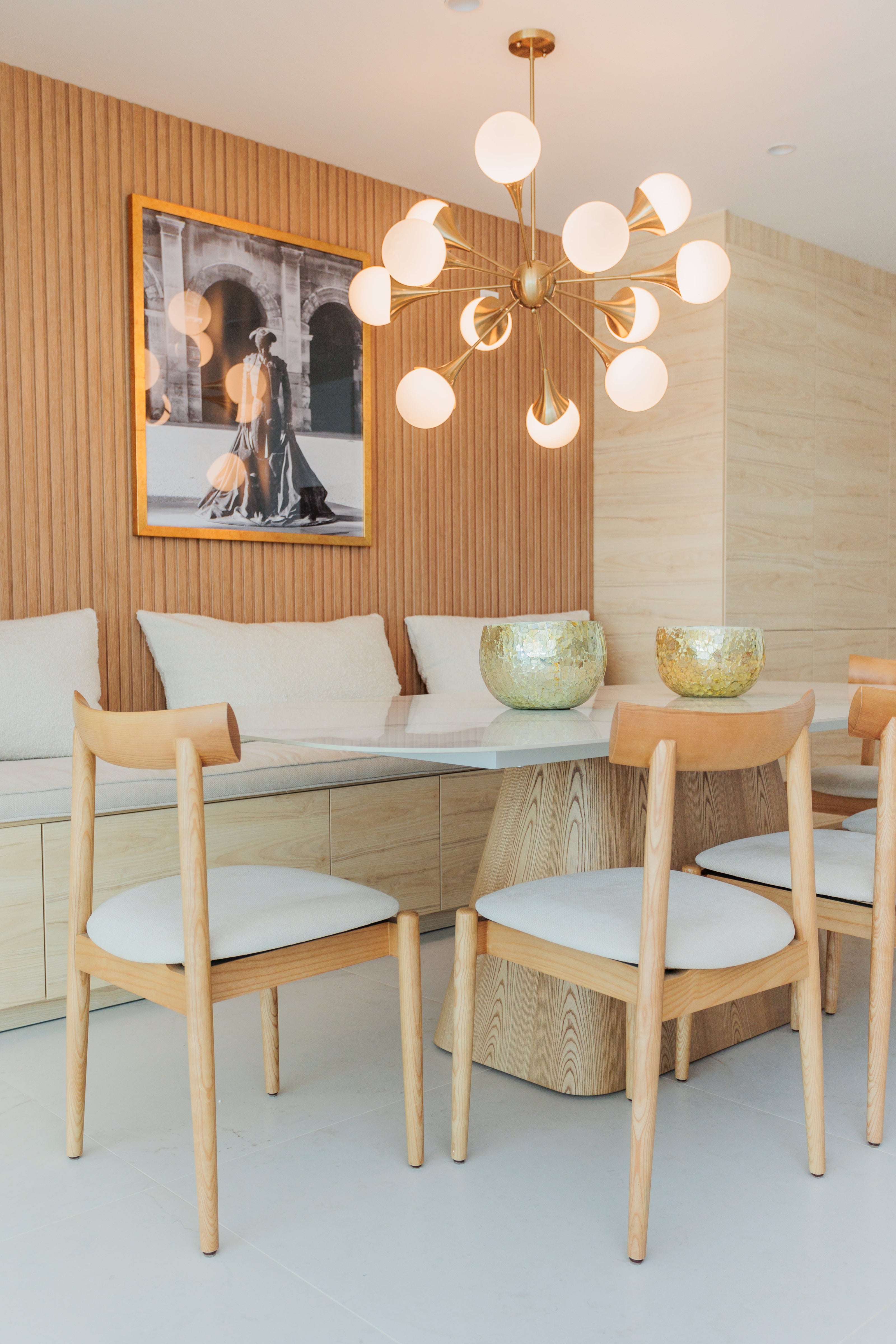 luxury interior design for dining room with wooden dining chairs, golden ceiling lamp, wooden panels, wooden legs marble top dining table available in marbella, benahavis, malaga, costa del sol.