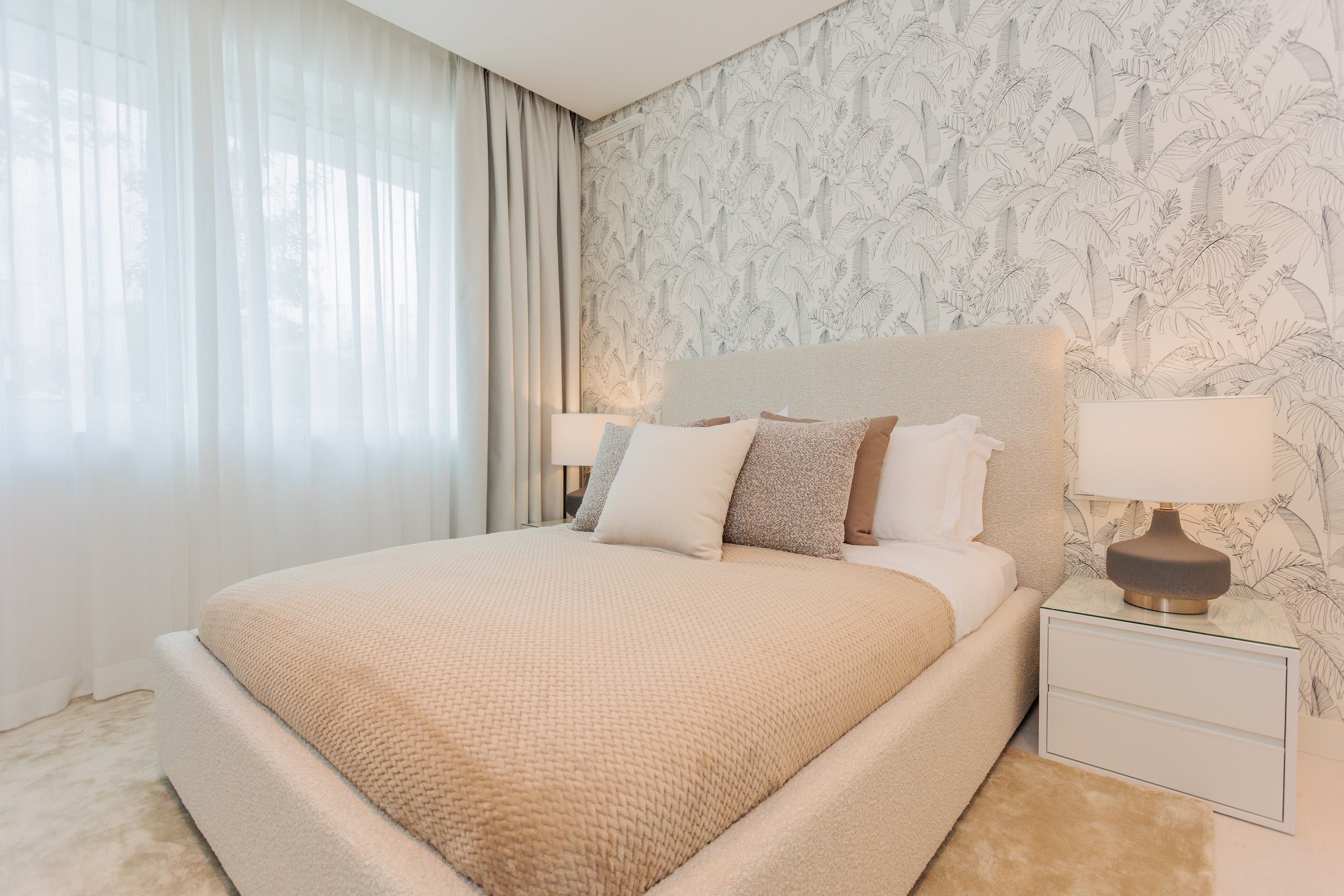 luxury interior design, home design with cream colored bed, pillows, clean wallpaper, bedside table, modern table lamps, made to measure curtain available in alcazaba, marbella, malaga, costa del sol, bel air.