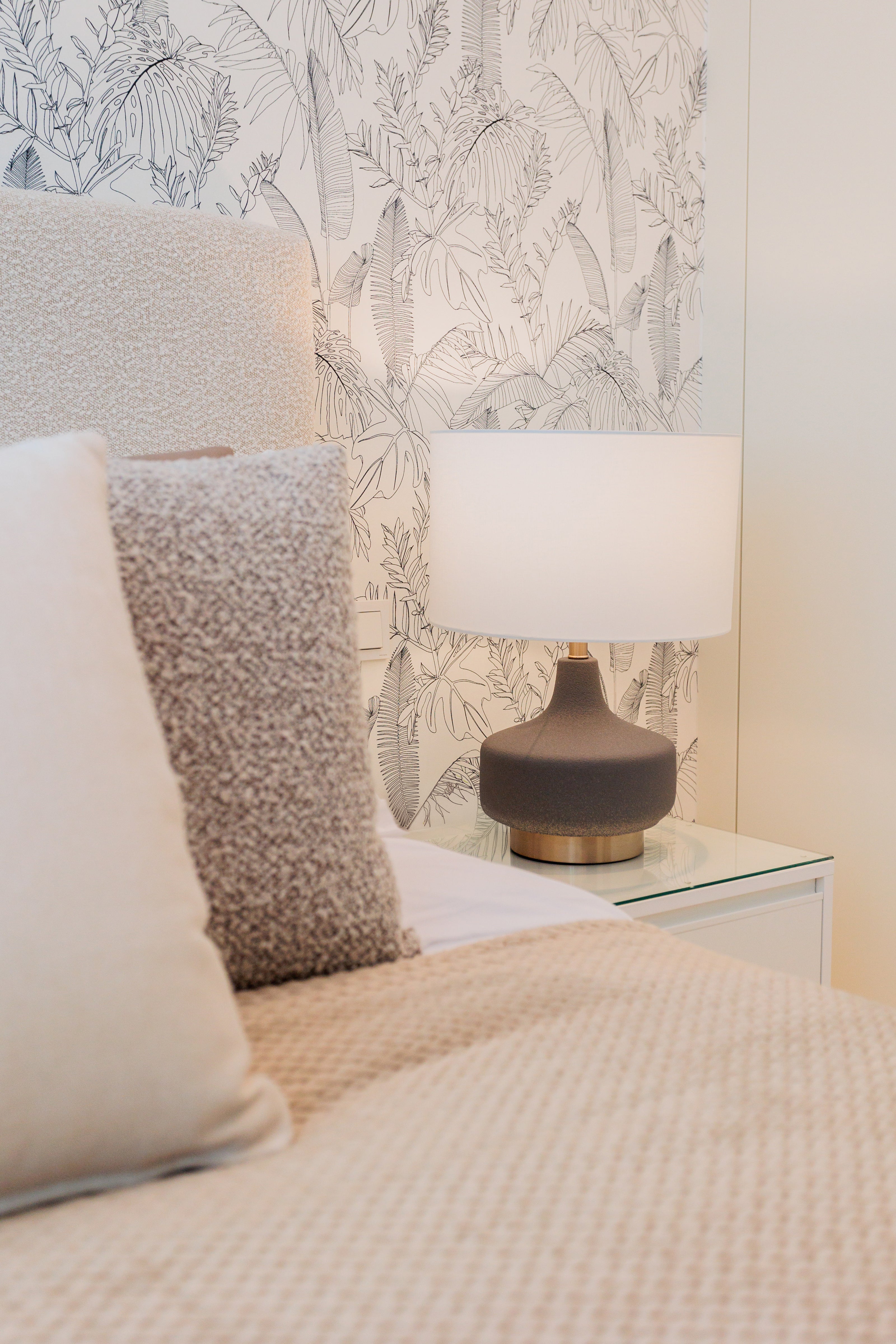 modern cream brown interior design for bedroom with brown and gold lamp and clean black and white wallpaper available in bel air, marbella, malaga, costa del sol.