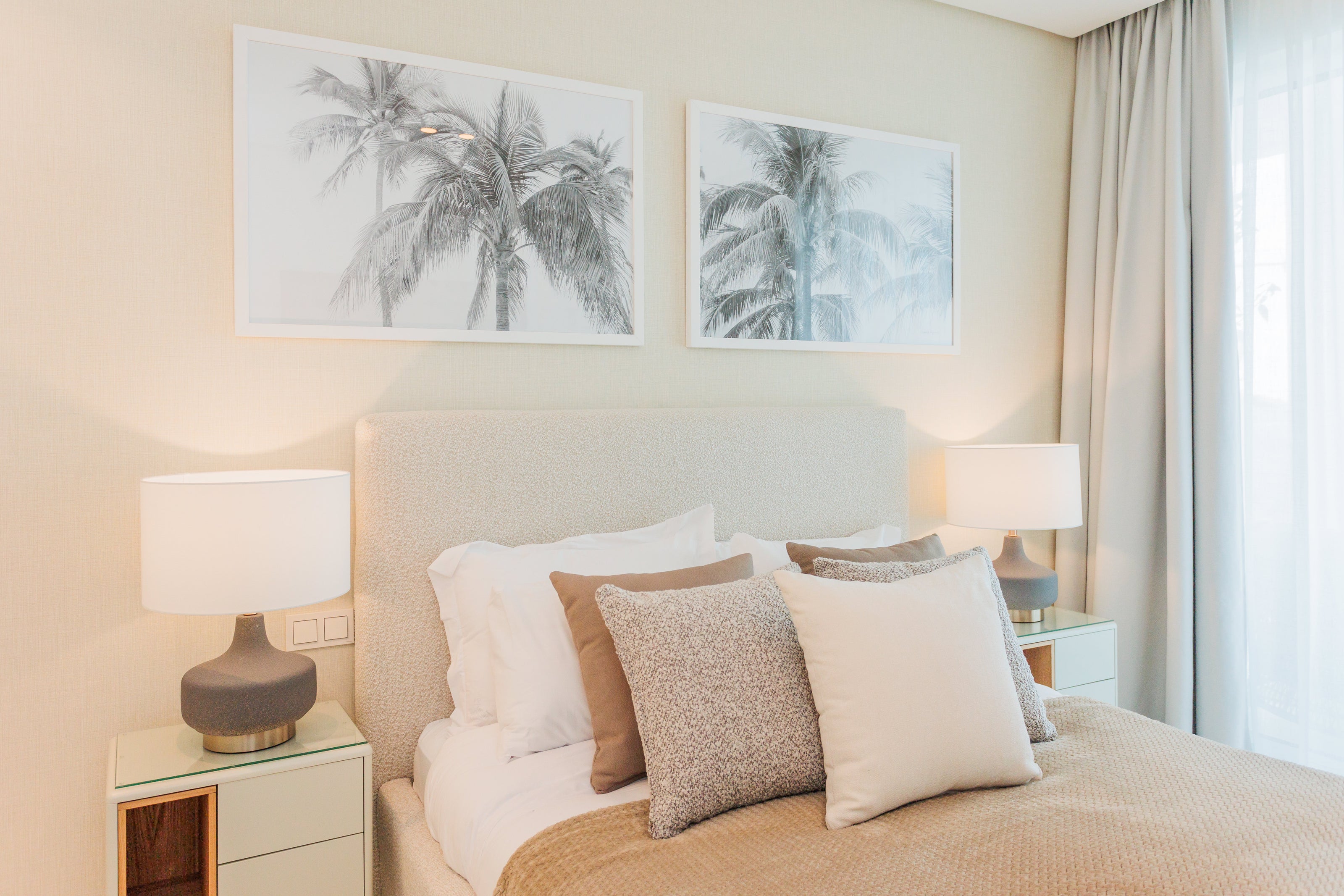 luxury interior design for bedroom with artworks, headboard, bed, pillows, bedside table, table lamps, and made to measure curtains available in marbella, malaga, estepona, bel air.