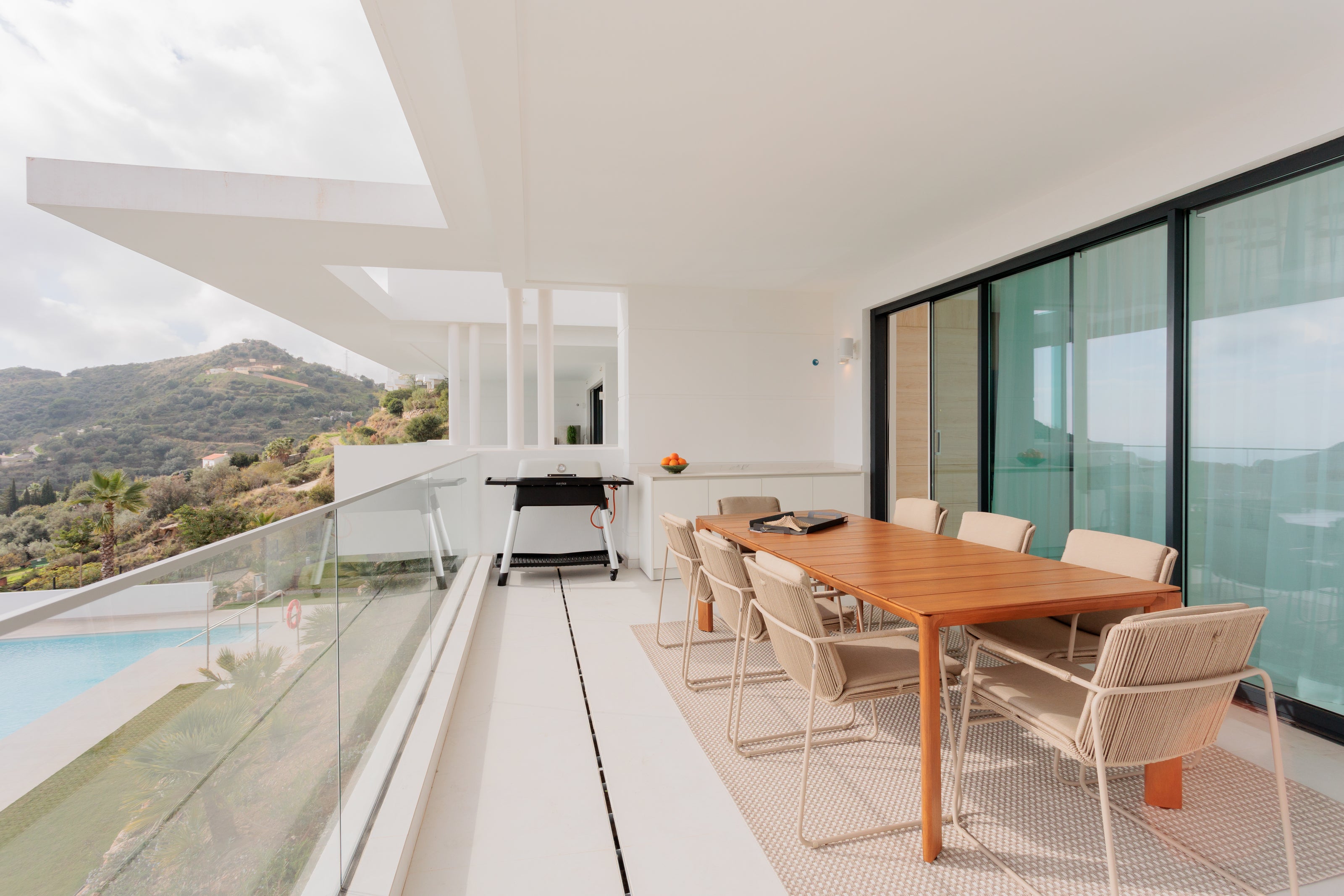 luxury modern outdoor living interior design with outdoor wooden dining table, outdoor chairs available in marbella, malaga, estepona, costa del sol, bel air.