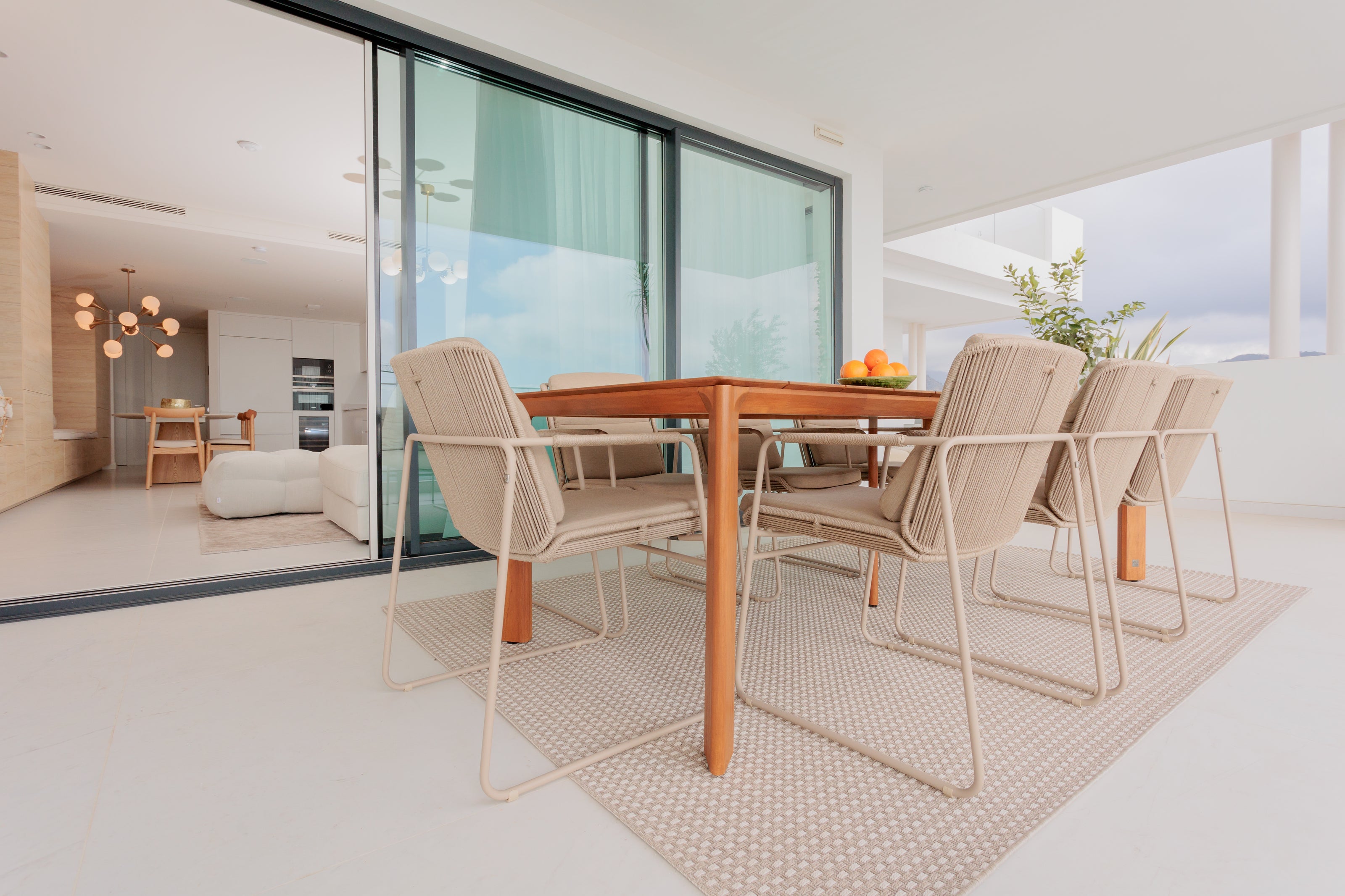 modern outdoor dining interior design, with wooden dining table, aluminium outdoor dining chairs, outdoor rug available in casares, marbella, malaga, costa del sol, bel air.