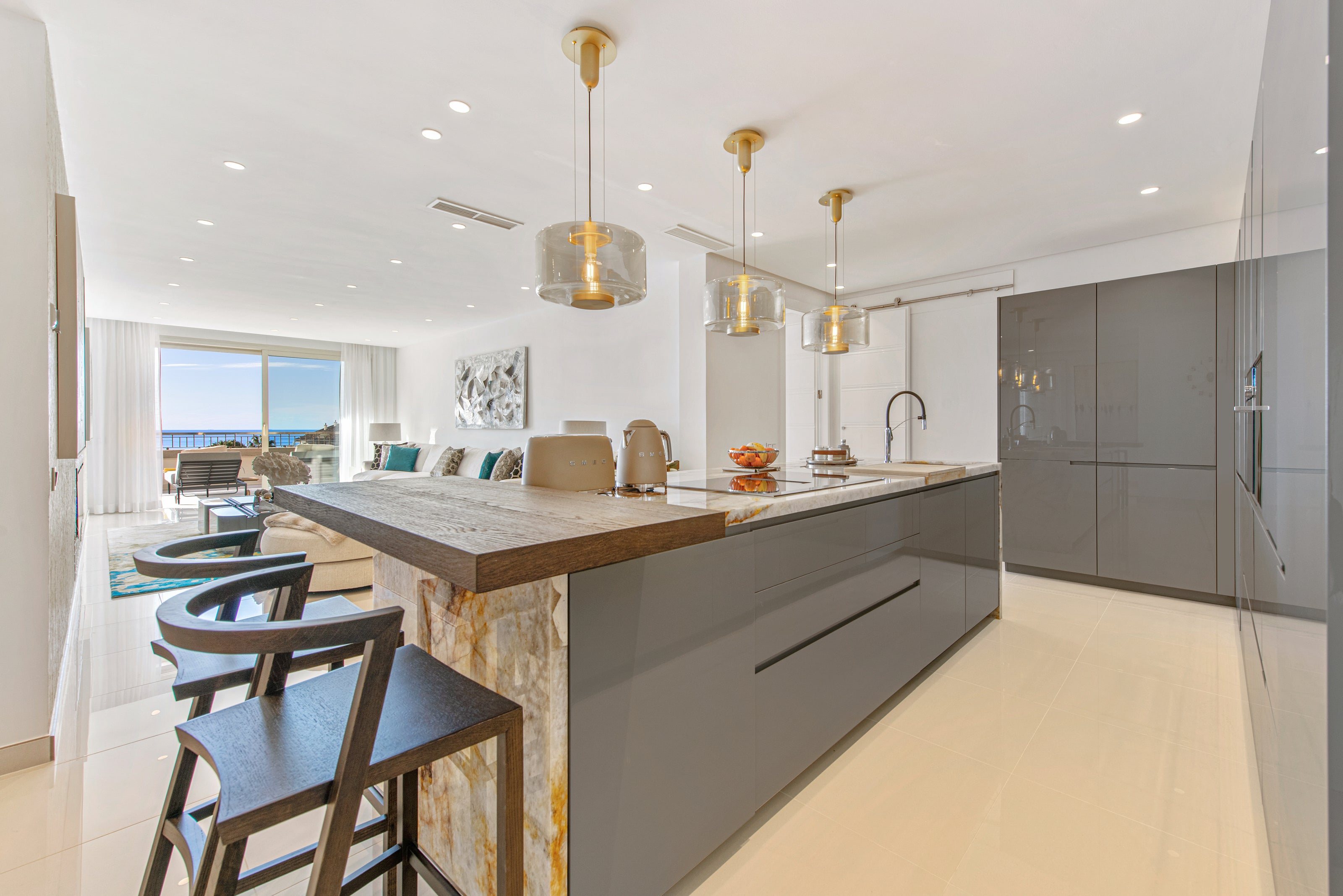 finished interior design project for kitchen and living room with colors blue green and gold, ceiling lamp, bar stools available in bel air, marbella, malaga, costa del sol, estepona.