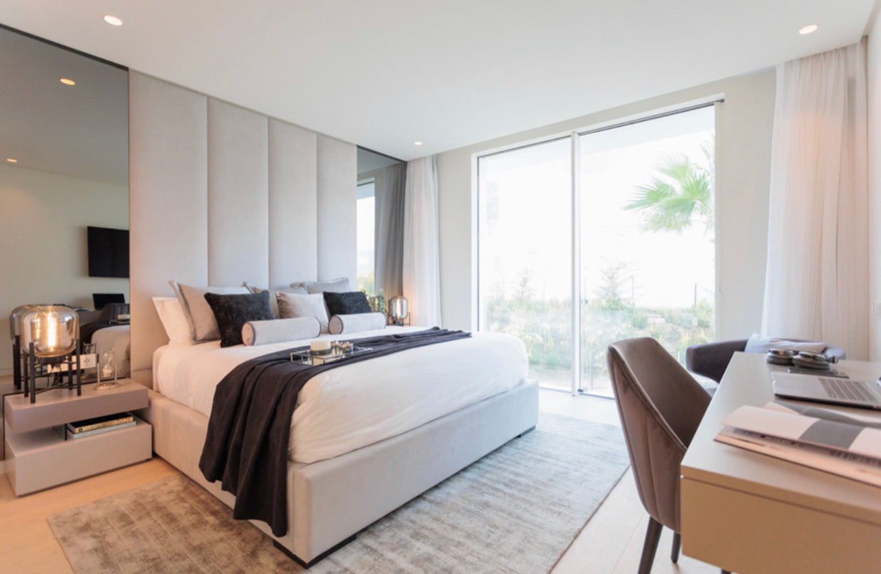 modern elegant interior design for bedroom with mirrors, bedd, bedside table, table lamps, rugs, desk, and chair available in alcazaba, marbella, malaga, costa del sol.
