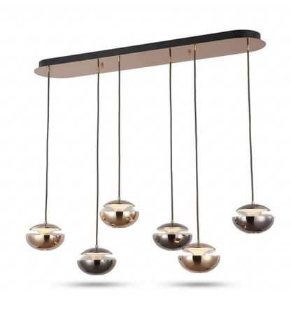 Modern multi-light linear pendant chandelier with six spherical glass shades in brushed gold, bronze, and silver finishes, suspended from a matte black bar with a warm beige underside, shown on a white background.