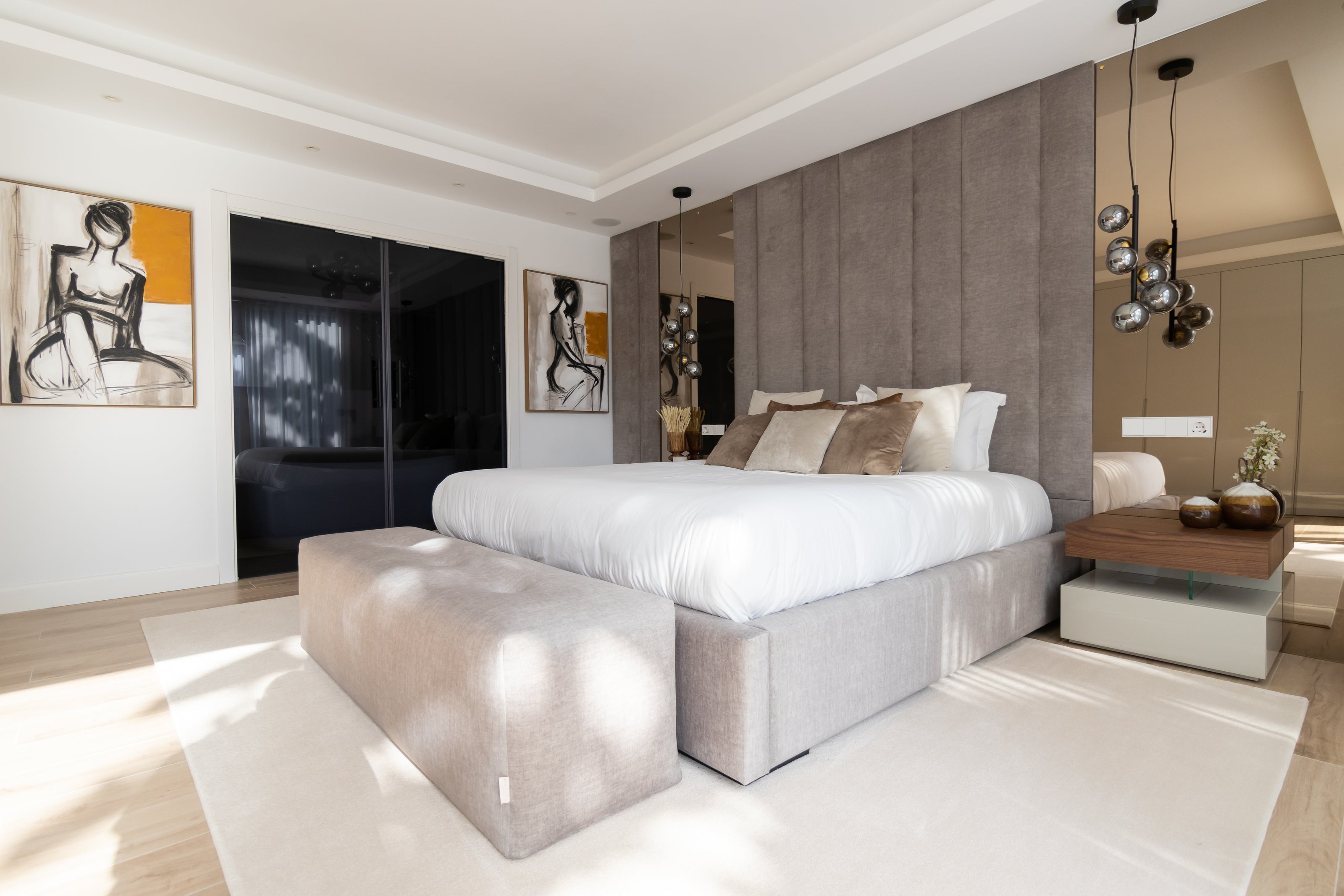 Interior design project for bedroom with mirrors, elegant bed, ottoman, rug, bedside table, bronze mirror and artworks available in malaga, marbella, costa del sol