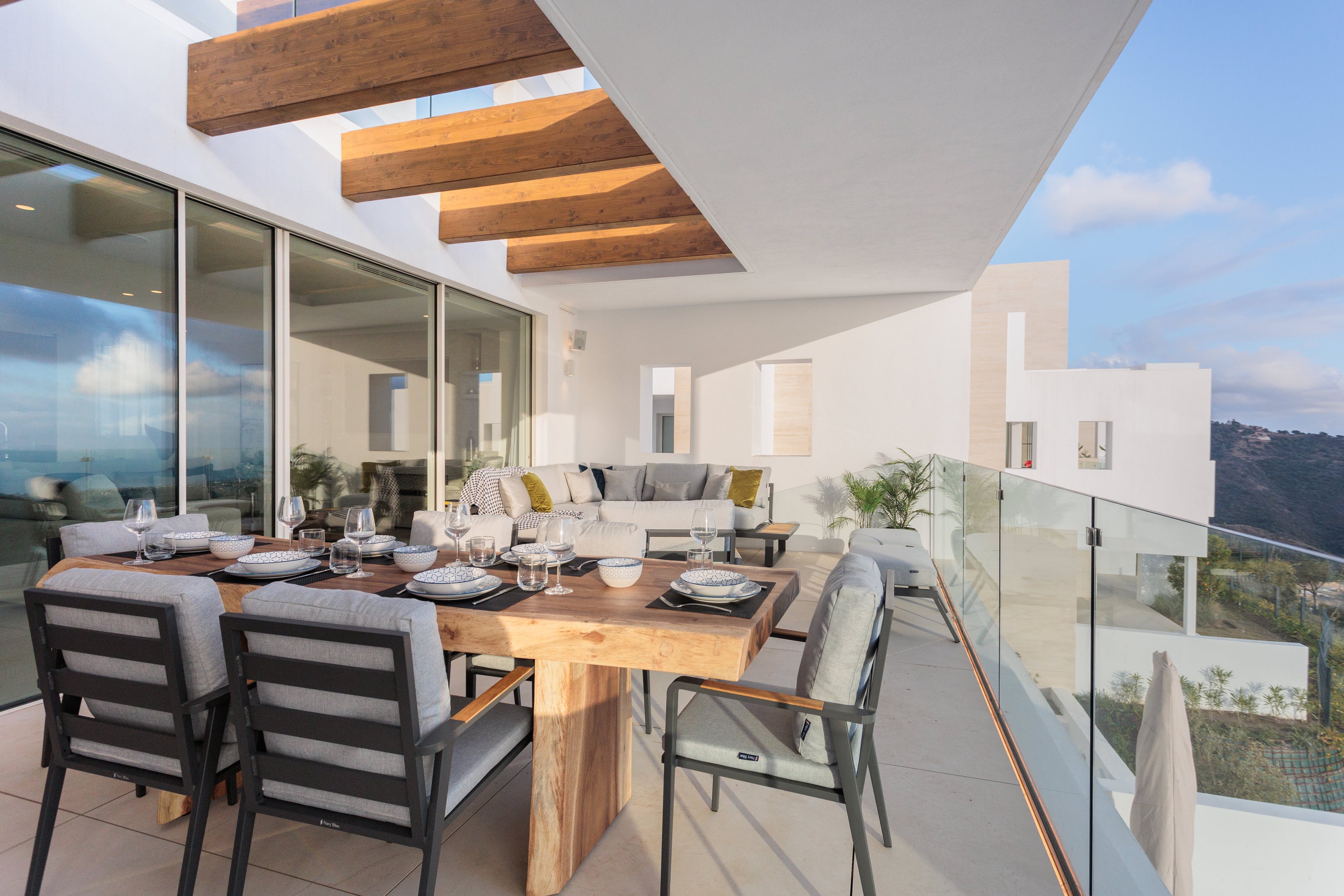 outdoor interior design with living sofas, coffee table, dining table, dining chairs made of aluminium and wood available in alcazaba, marbella, malaga, gibraltar, palo alto.